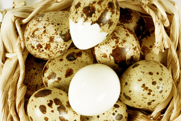 Boiled spotted quail eggs in a wicker basket, isolated on white background.  Healthy Food Products Concept.