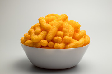 cheese puffs in a white bowl, Cheese Doodle Day, crisps, puffcorn - obrazy, fototapety, plakaty