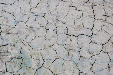Obraz premium Peeling paint on the wall. Old concrete wall with cracked flaking paint. Weathered rough painted surface with patterns of cracks and peeling. High resolution texture for background and design. Closeup