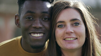 Happy diverse couple smiling at camera. African man and white girl face close-up smile at camera