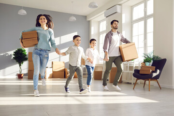Happy family with little kids running to explore new home. Parents and children holding hands as they enter newly bought house or apartment on moving day. Real estate business and mortgage concept