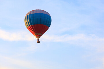 tricolor hot air balloon in the sky with clouds