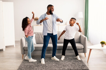 Fototapeta premium African american dad dancing to music with his little children