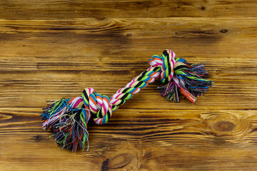 Colorful rope toy for dog on wooden background