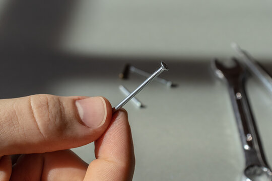 Building hobnail. Tools for repair. Male hands holding a hobnail 