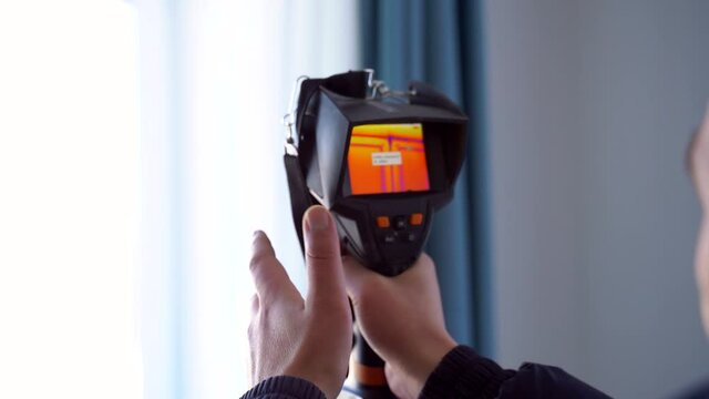 Inspection of a window block inside the room with a thermal imager for heat leakage.