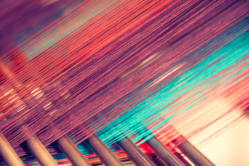 Multicolored straight strands texture background, sewing equipment, loom equipment at a garment...