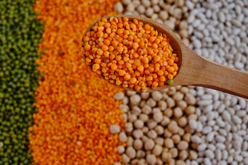 Orange lentils in a wooden spoon