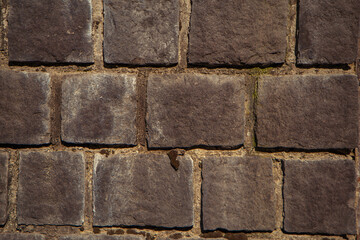 old masonry, fragment of gray stone wall, wall masonry from old stone blocks, background texture of an ancient brick wall