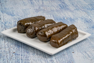 stuffed grape leaves with olive oil on plate on the table
