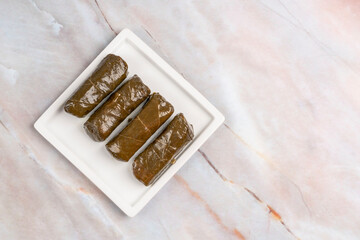 stuffed grape leaves with olive oil on plate on the table