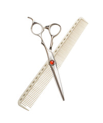 Elegant hairdressing scissors decorated with a red gemstone. Damascus scissors and comb. Isolated...