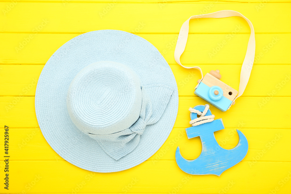 Wall mural summer straw hat with wooden camera and anchor on yellow background