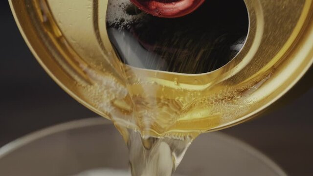 Pour beer from a can in close up macro