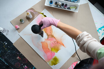 Woman drawing with alcohol ink at home. Above Shot 