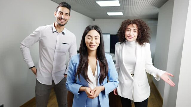 Portrait of three positive multiethnic businesspeople waving and talking at camera. Group of multiracial millennial men and women using virtual conference for business planning. Lifestyle and success.