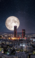 Night shot of the new downtown of Amman city with full moon behind modern towers