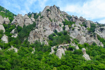 Fototapeta na wymiar Panorama of mountains in Valley of Ghosts, near Alushta, Crimea. Rocks have tracks of ages of strong weathering. Some of them turned into stand alone so called erosion columns
