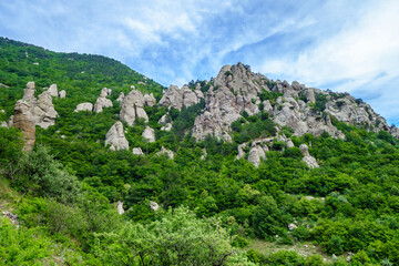 Fototapeta na wymiar Panorama of mountains & stone erosion columns in Valley of Ghosts, near Alushta, Crimea. These shapes were created by many ages of weathering. One of popular tourist places for hiking