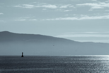 the sea in the morning hours and the mountains in the haze