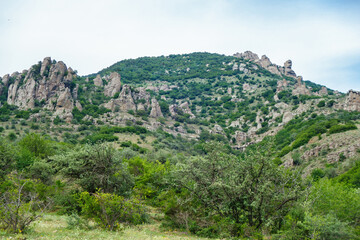 Fototapeta na wymiar Panorama of mountains in Valley of Ghosts, near Alushta, Crimea. Place popular among tourists for hiking. Some strange shaped rocks have own name. Rock named 'Head of Empress Catherine' in right side