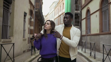 Young interracial couple walking together, modern millennial boyfriend and girlfriend in street