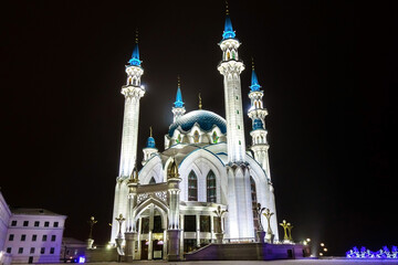 Fototapeta na wymiar Mosque of Kul Sharif in winter night. Building is illuminated by electric light and looks a bit mysterious in the dark. Shot in Kazan, Russia. Writing above door is name of mosque in Tatar
