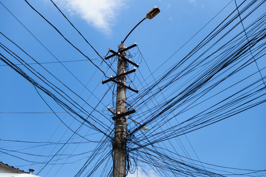 City lamppost with communications connected to it. The number of wires and cables exceeds every conceivable limit