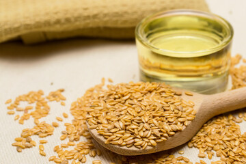 Golden flaxseeds or linseeds, close up with flaxseed oil