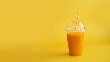 A plastic cup of orange drink. Natural juice or smoothies. Healthy food. Vegetarian or vegan food...