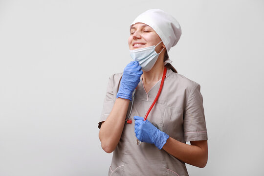 Relaxed Woman Breathing With The Mask Removed. Concept Of Taking Off The Mask.Breath Pure Air. Ending Of Quarantine Corona Virus Covid-19 Concept.difficulties And Problems At Work Of A Medical Worker