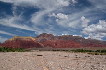 Arid desert landscape in the Andes mountain range. View of the sand red canyon and colorful mountains under a magical sky.   