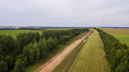 Fototapeta na wymiar Drone view of the new road. Aerial photography construction of a new highway. Construction stage. Road pavement layers. The composition of the road during its construction
