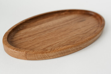 Wooden oval tray large on white background. Wooden utensils on white background. Dishes made of natural materials.