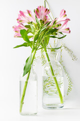 Flowers, alstroemeria in a glass vase with stems refracted through water. Close-up, vertical frame