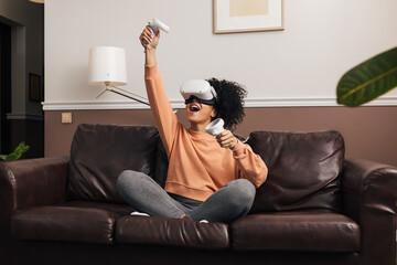 Young woman playing video games at home using VR set