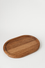 Comfortable wooden tray on a white background. Dishes made of ash wood. Wooden utensils.