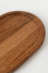 Half wooden tray on white background. Dishes made of ash wood. Wooden utensils.