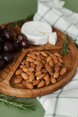 Mildewed cheese, nuts and grapes. A tasty and healthy dish on a green background. Useful and healthy food.
