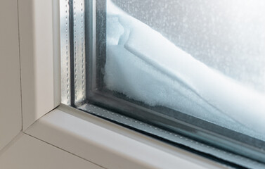 The window sill is covered with snow at the window outside