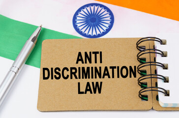 Against the background of the flag of India lies a notebook with the inscription - ANTI DISCRIMINATION LAW