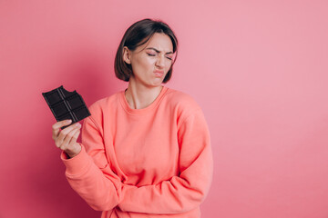 Naklejka premium Beautiful sad woman with abdominal pain with chocolate bar on pink background and bright makeup