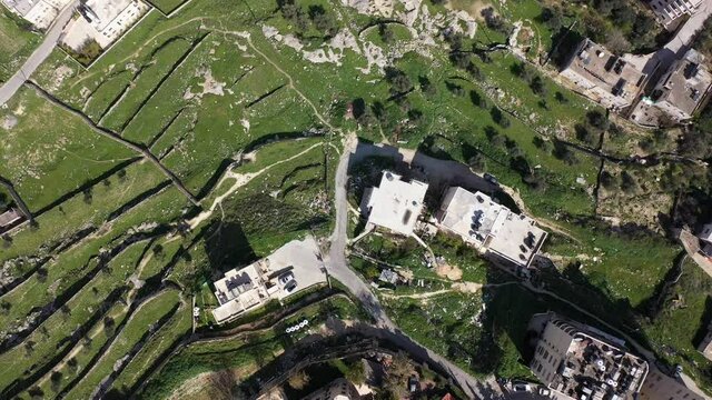 Aerial view over Bethlehem City, Palestinian Authority
Drone view over buildings and green fields in the morning
