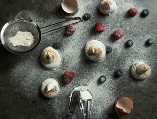 Flat lay of meringue, eggs berries and sugar powder