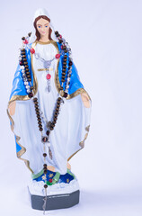 Statue of Virgin Mary with rosary on neck on white background