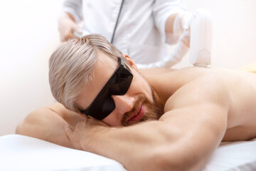 Obraz na płótnie Canvas Hair removal cosmetology procedure from men back laser epilation studio