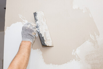hand of builder worker plastering at wall.Renovation workers hand plastering the wall.Construction...