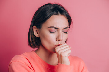 Woman wearing casual sweater on background feeling unwell and coughing as symptom for cold or bronchitis. Healthcare concept.
