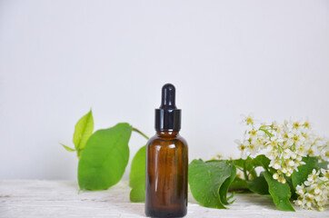 Herbal essence. Alternative healthy medicine. Skin care. Essential oil bottle White flowers on white wooden background