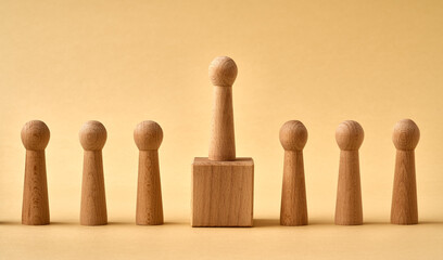 One wooden figure standing higher than others - leadership or winning concept